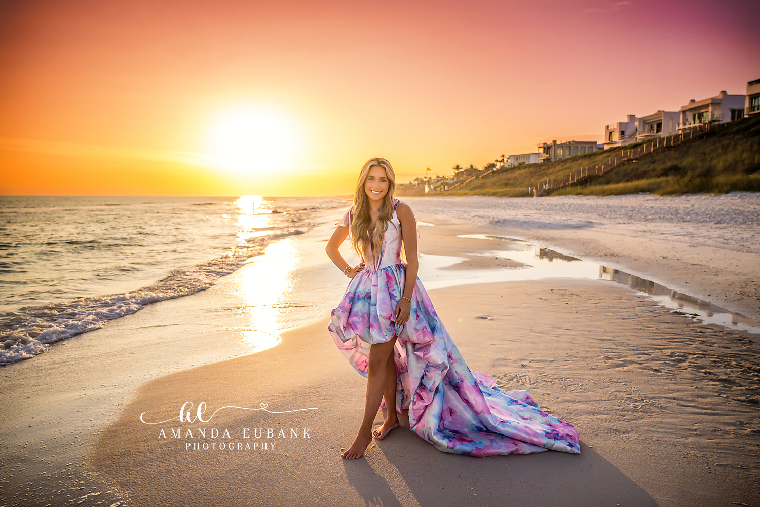 Sun Path on the Water — Tampa Bay Senior Photography A senior in a printed gown on the shoreline with the sun's path across the water at a beach senior session in Tampa, FL.