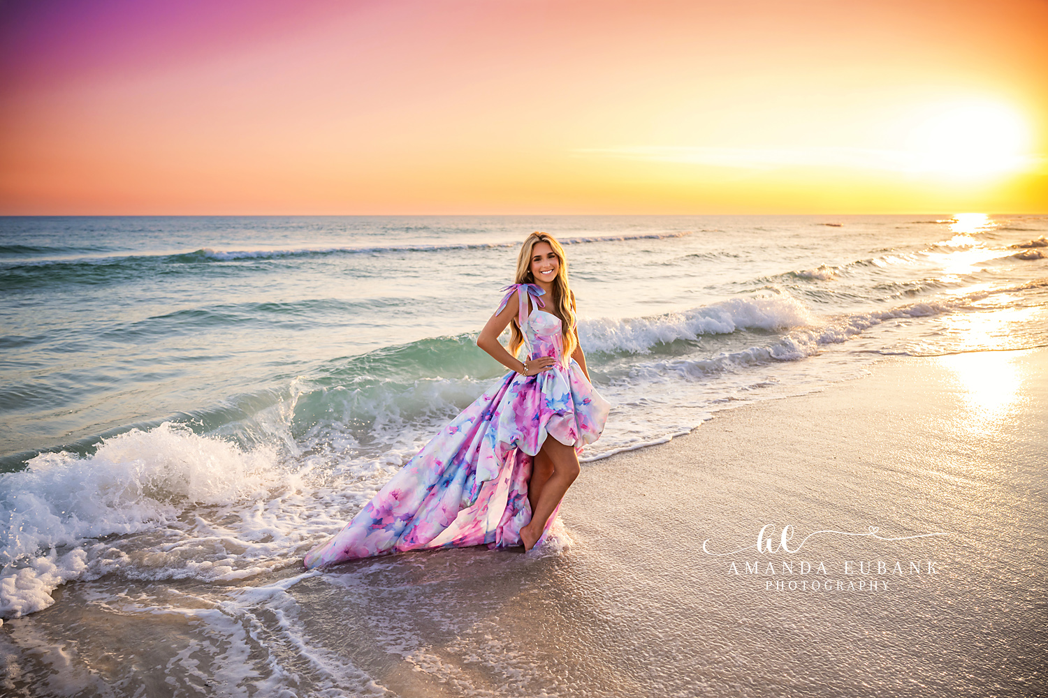 Waves and Golden Light | Beach Senior Session in Tampa, Florida Senior pictures in Tampa Bay showing a senior in a printed gown in the waves with the sun burning gold behind.