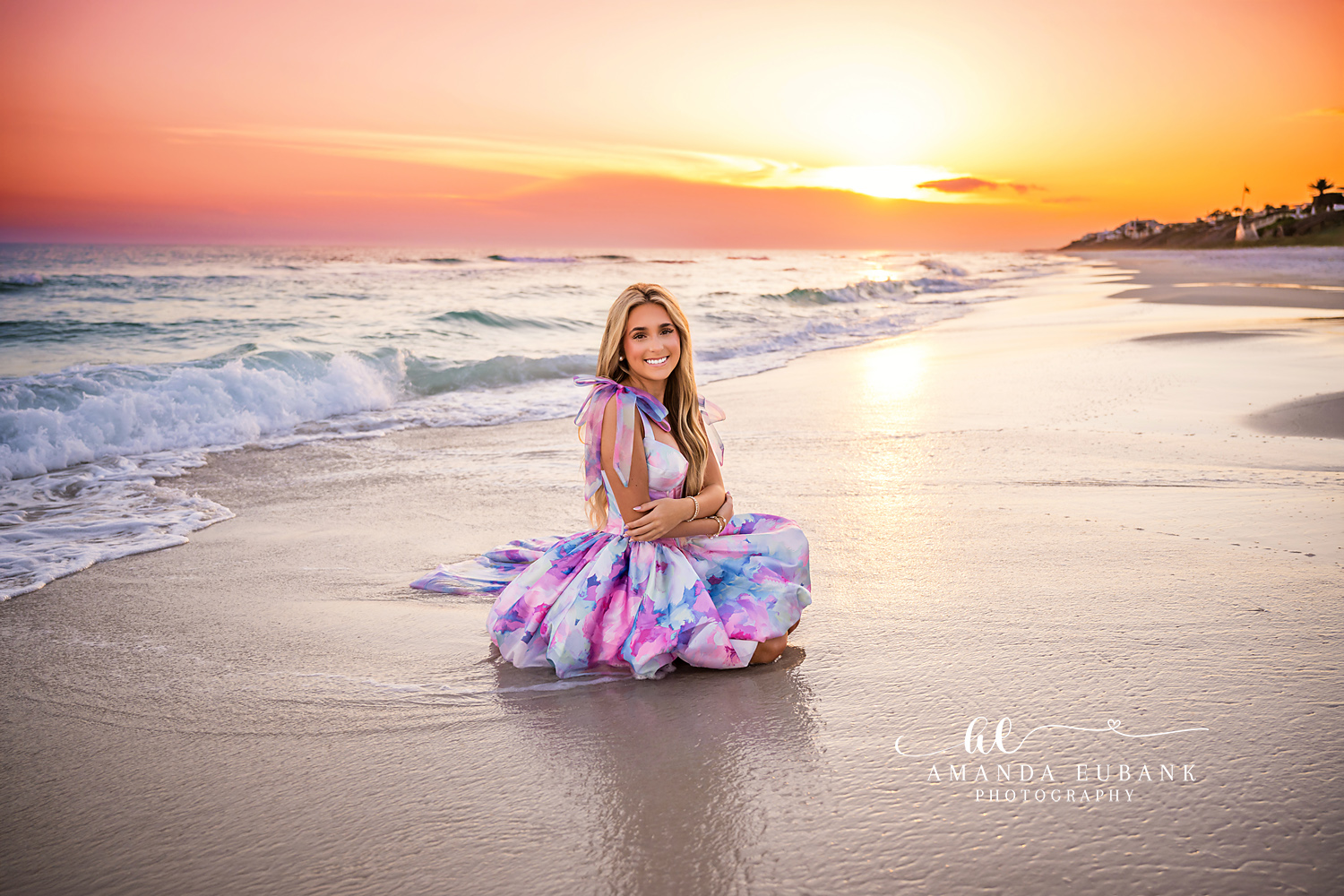Sunset Path Behind Her | Senior Portraits in Tampa, FL Tampa senior photographer captures a senior in a printed gown seated on the sand with the sun low over the Gulf.