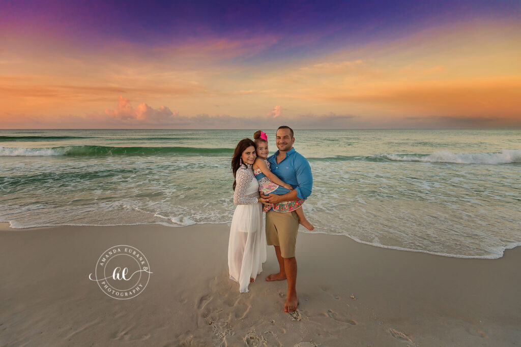 A couple standing in the surf beneath pastel clouds during a Venice Beach engagement photography session